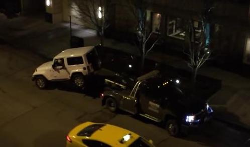 man drives jeep off tow truck with dog inside